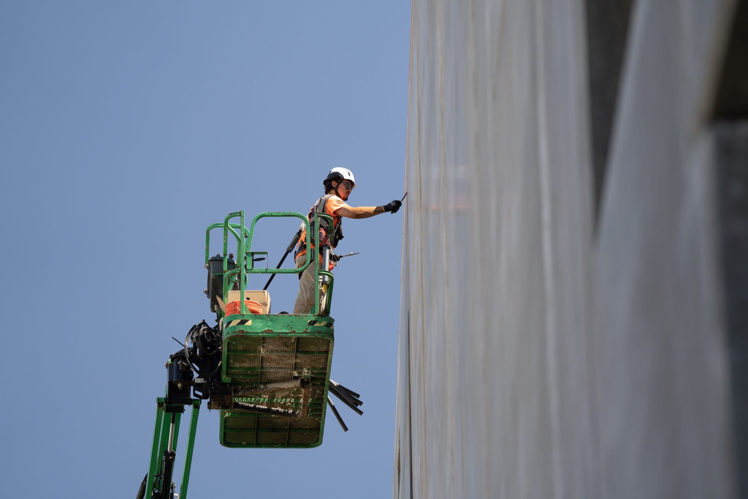 Sawtooth Fortified caulker sealing a precast panel joint from a boom lift